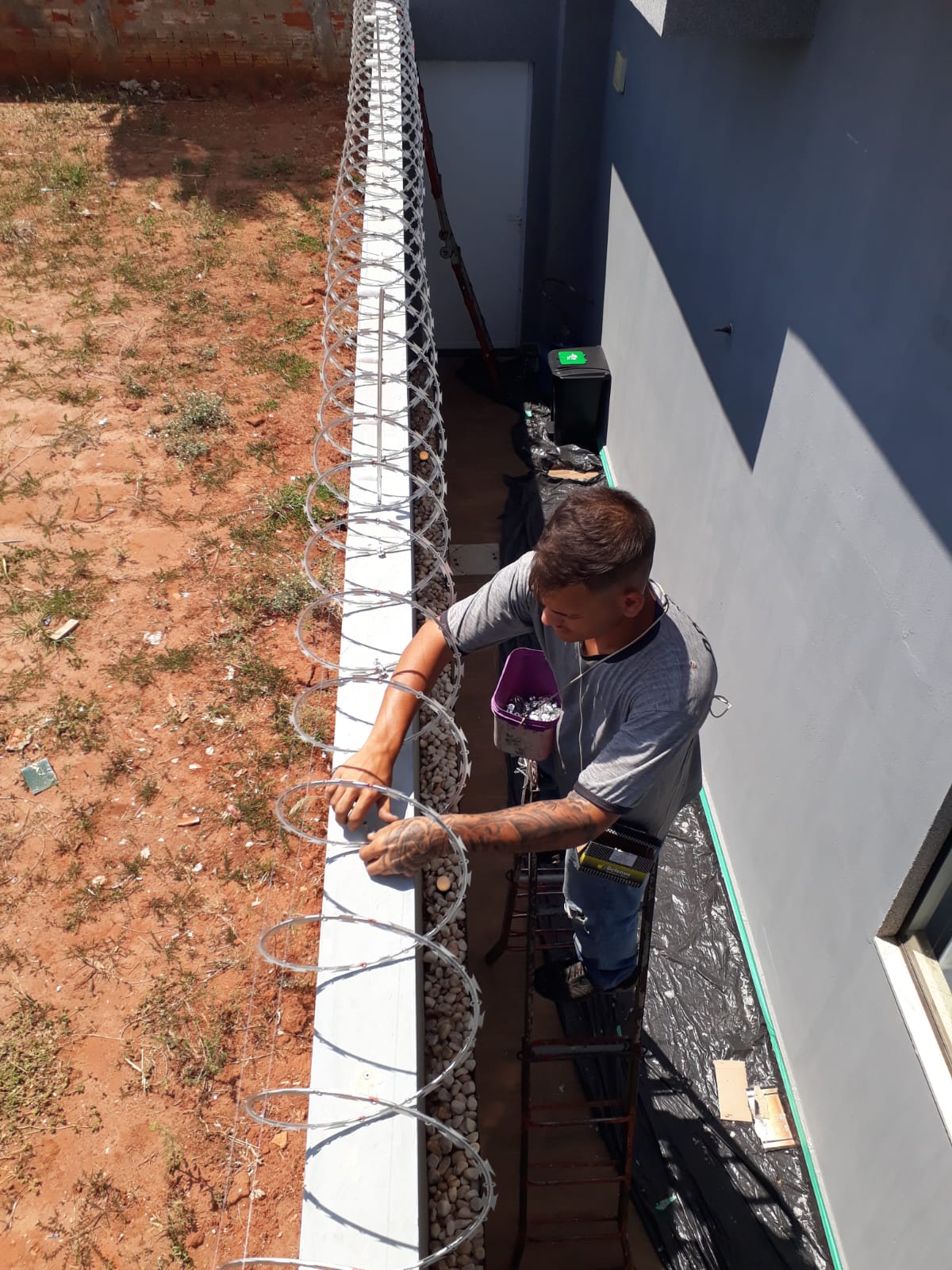 Profissional da Proteção realizando instalação de concertina